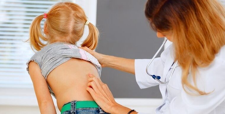 bel ağrısı nedeniyle çocuğun sırtını inceleyen doktor